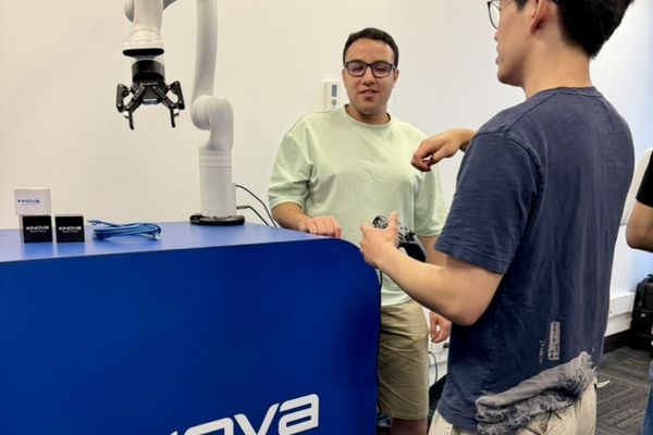 Two students using a robot arm