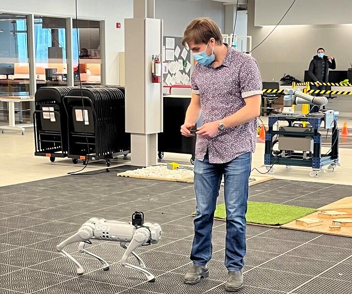A student walking beside a Robotic Dog Unitree Go 1 