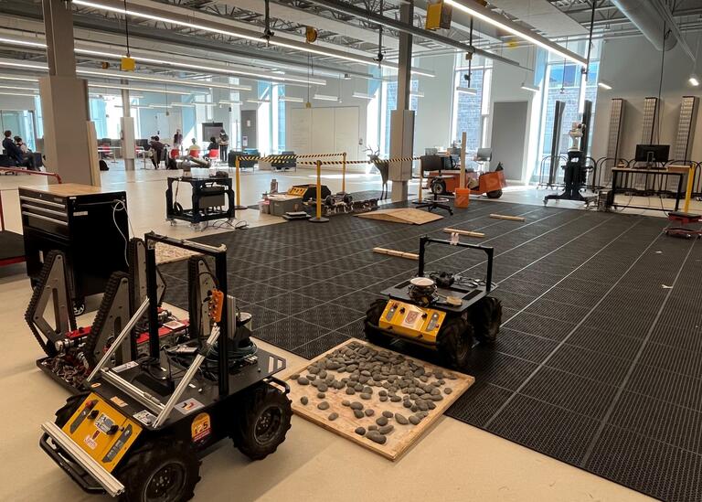 Open research space with a black tiled floor. Featuring two Husky Robots 