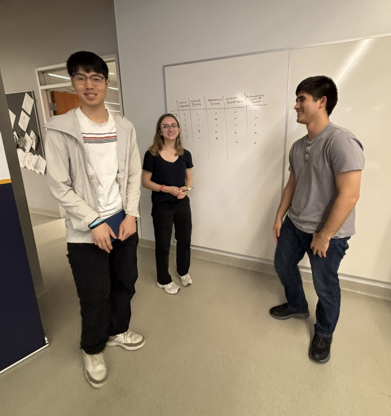 Three students standing in front of a whiteboard