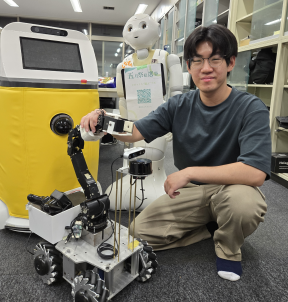 Tyler Chung next to a mobile robot