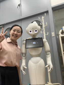Jenny Lee posing with a white humanoid robot