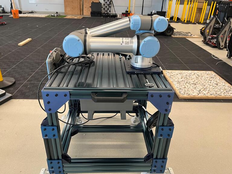 UR5e robot arm on a blue stand. 