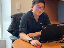 Dr. Matthew Pan sitting at a desk in a Drop In Office.