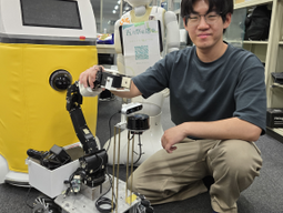 Tyler Chung next to a mobile robot