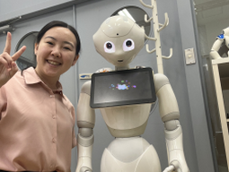 Jenny Lee posing with a white humanoid robot