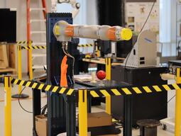 Kuka iiwa robot arm surrounded by caution stands.