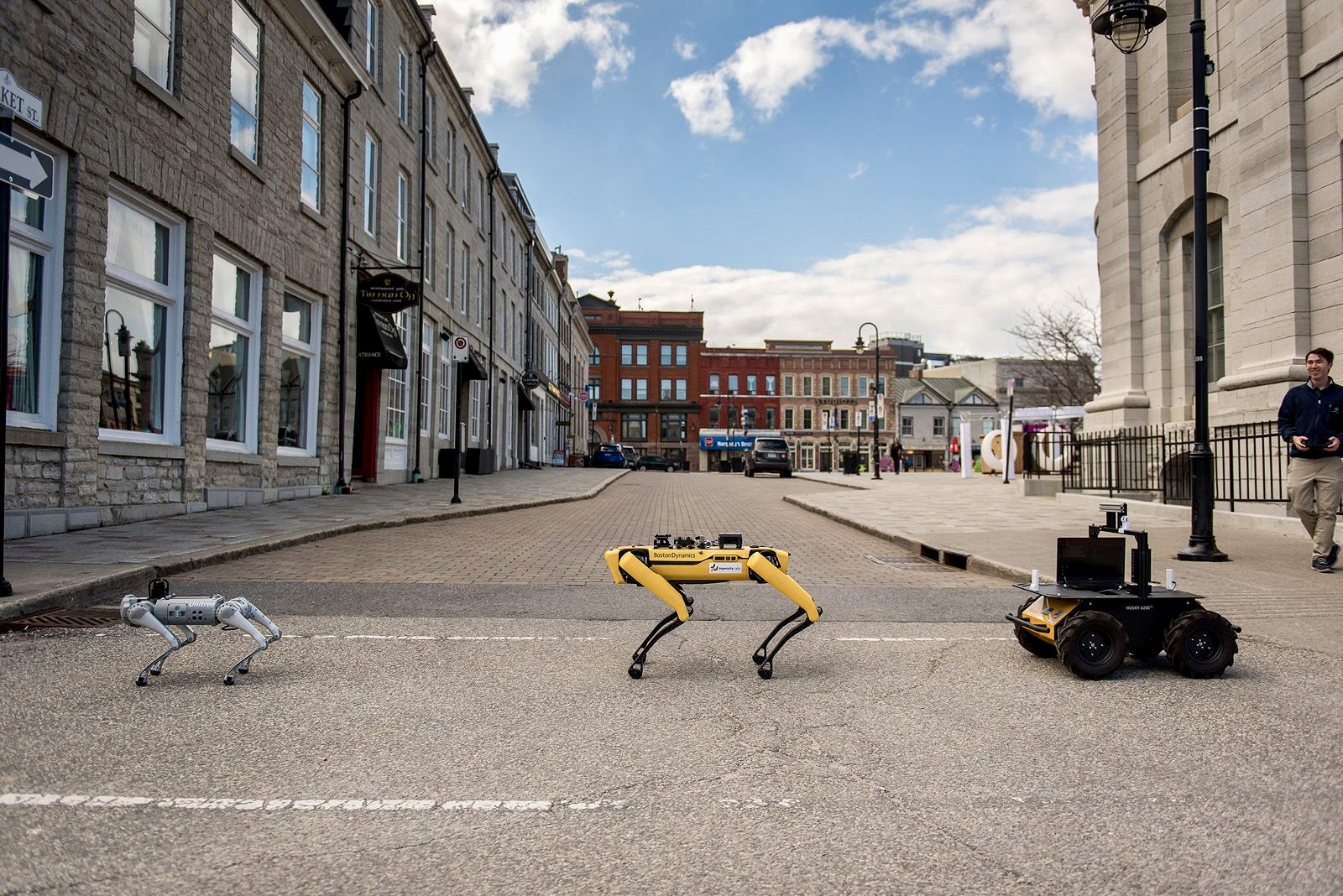 3 mobile robots walking across the street in a line