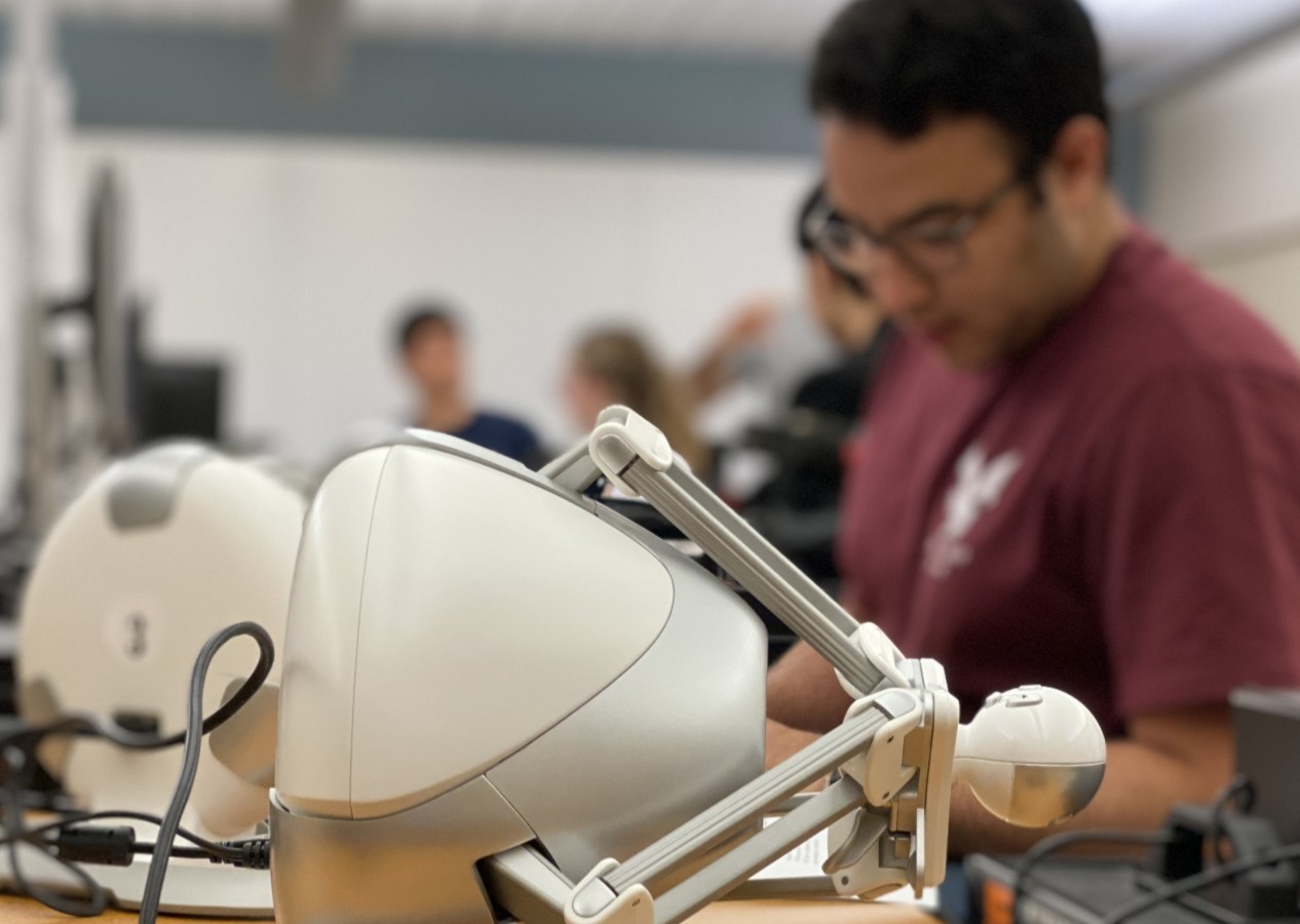 Close-up photo of an ADVENTOR trainee and a robot prototype